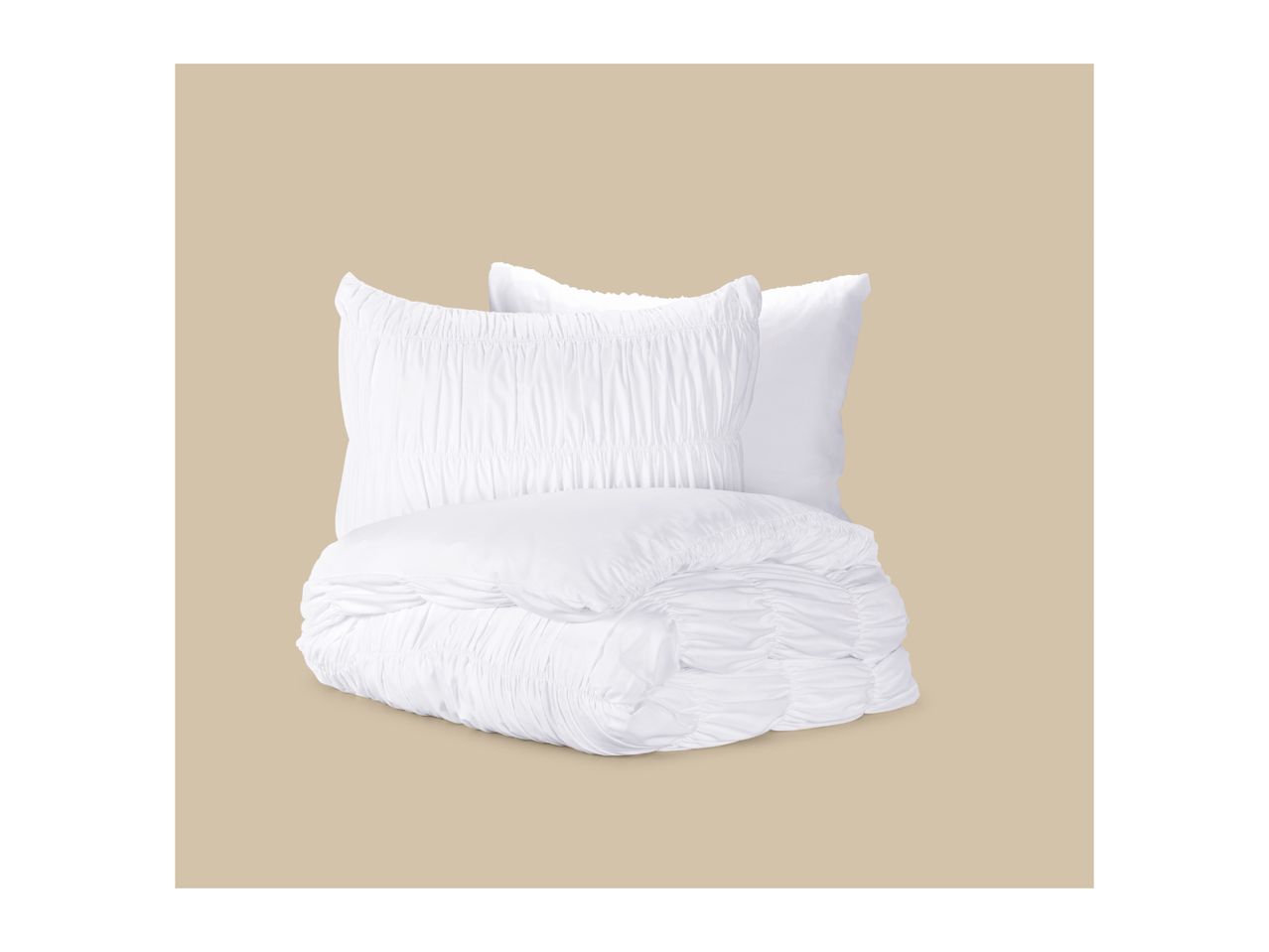 White ruched bedding set with a folded duvet and two pillows against a beige background