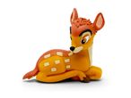A cute Bambi deer figurine, lying down, with orange and yellow colors and white spots.