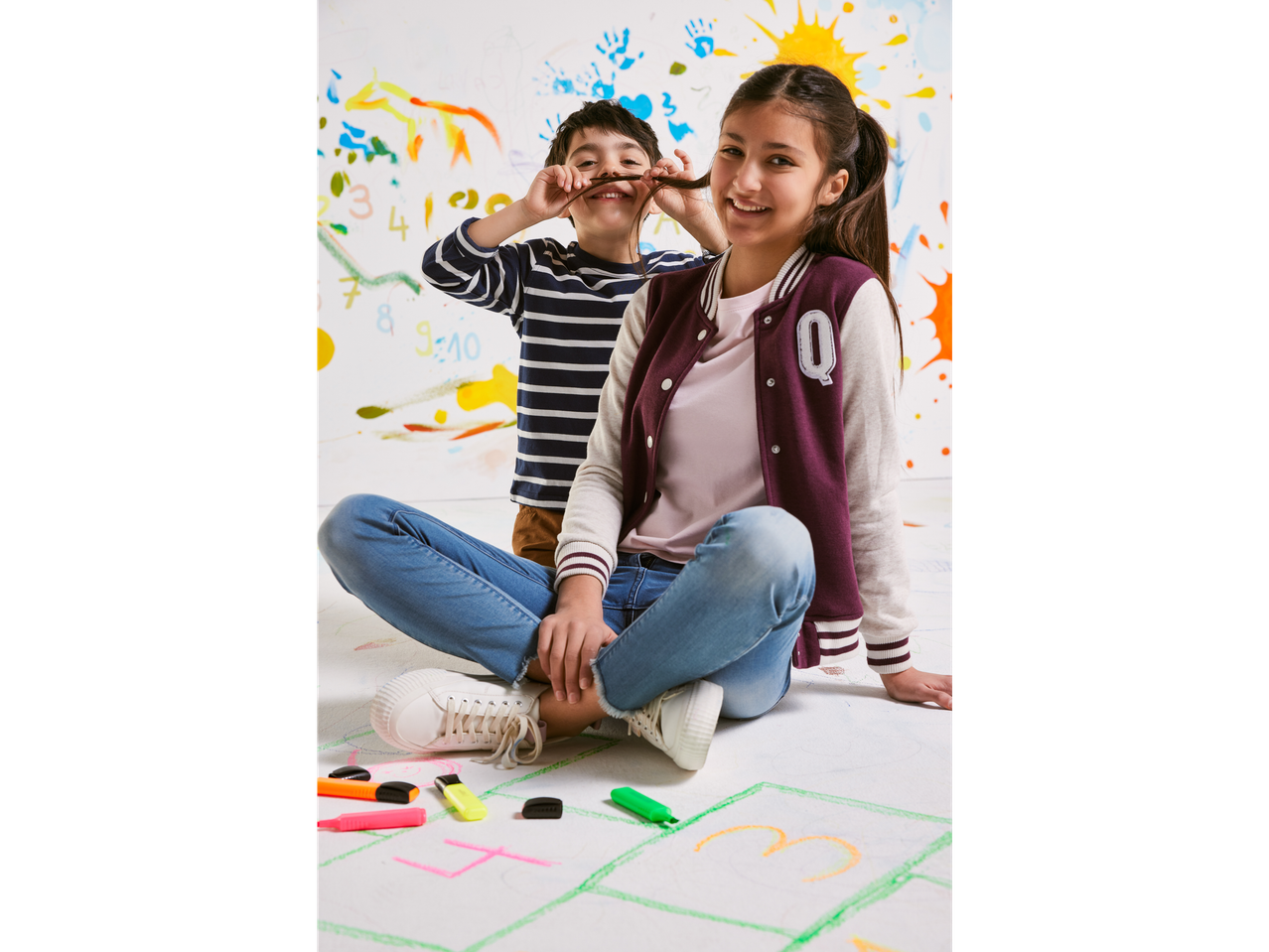 Copii jucând hopscotch cu markere.