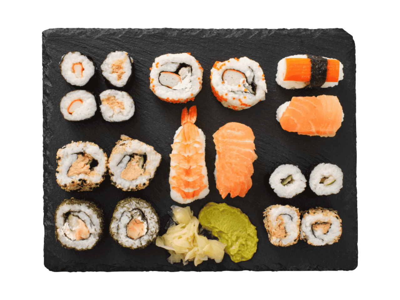 Suši un maki komplekts ar ingveru un vasabi uz melnas šīfera plāksnes.