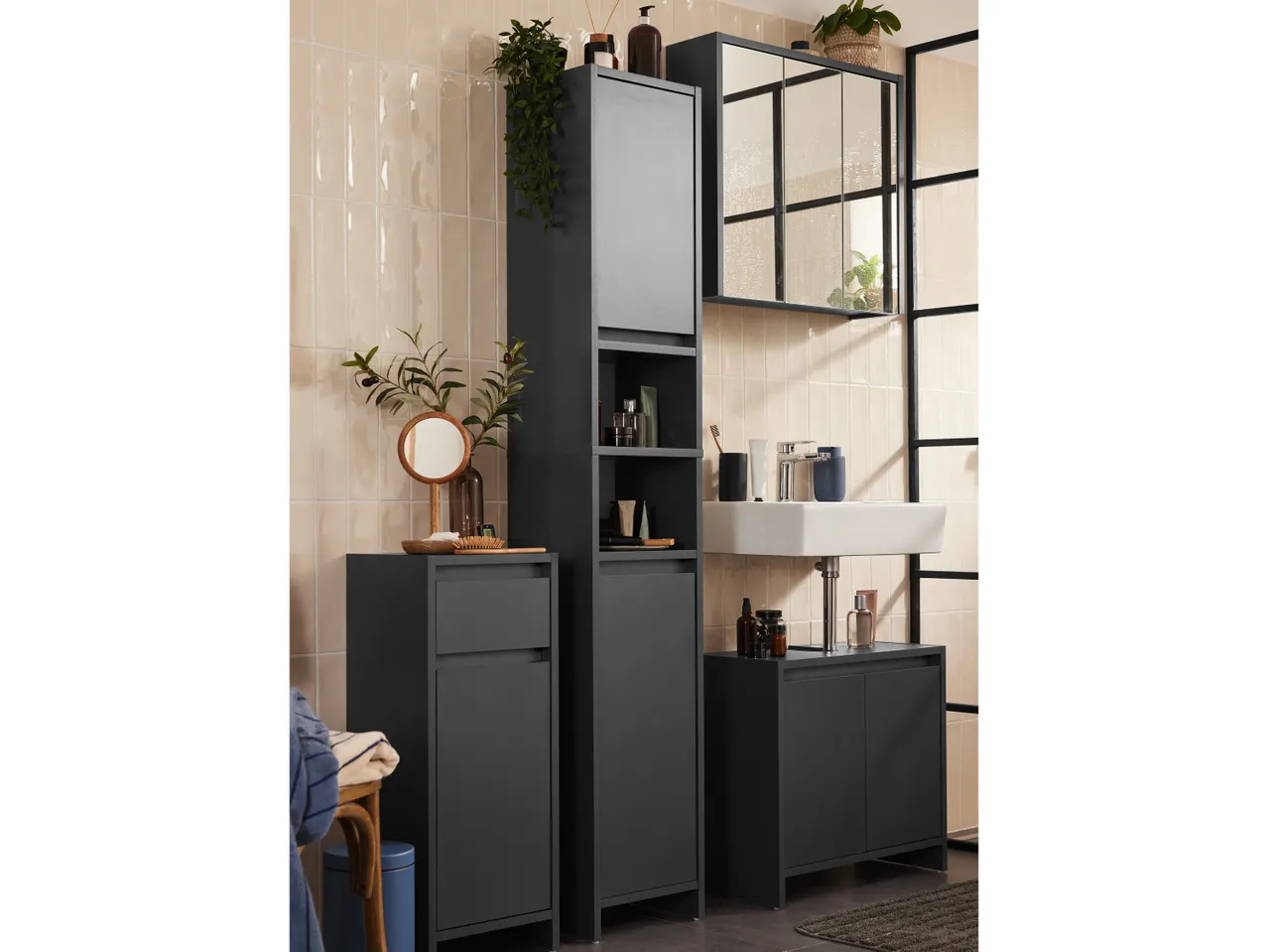 Arredamento bagno moderno e minimalista con mobiletto alto, specchio e lavabo.
