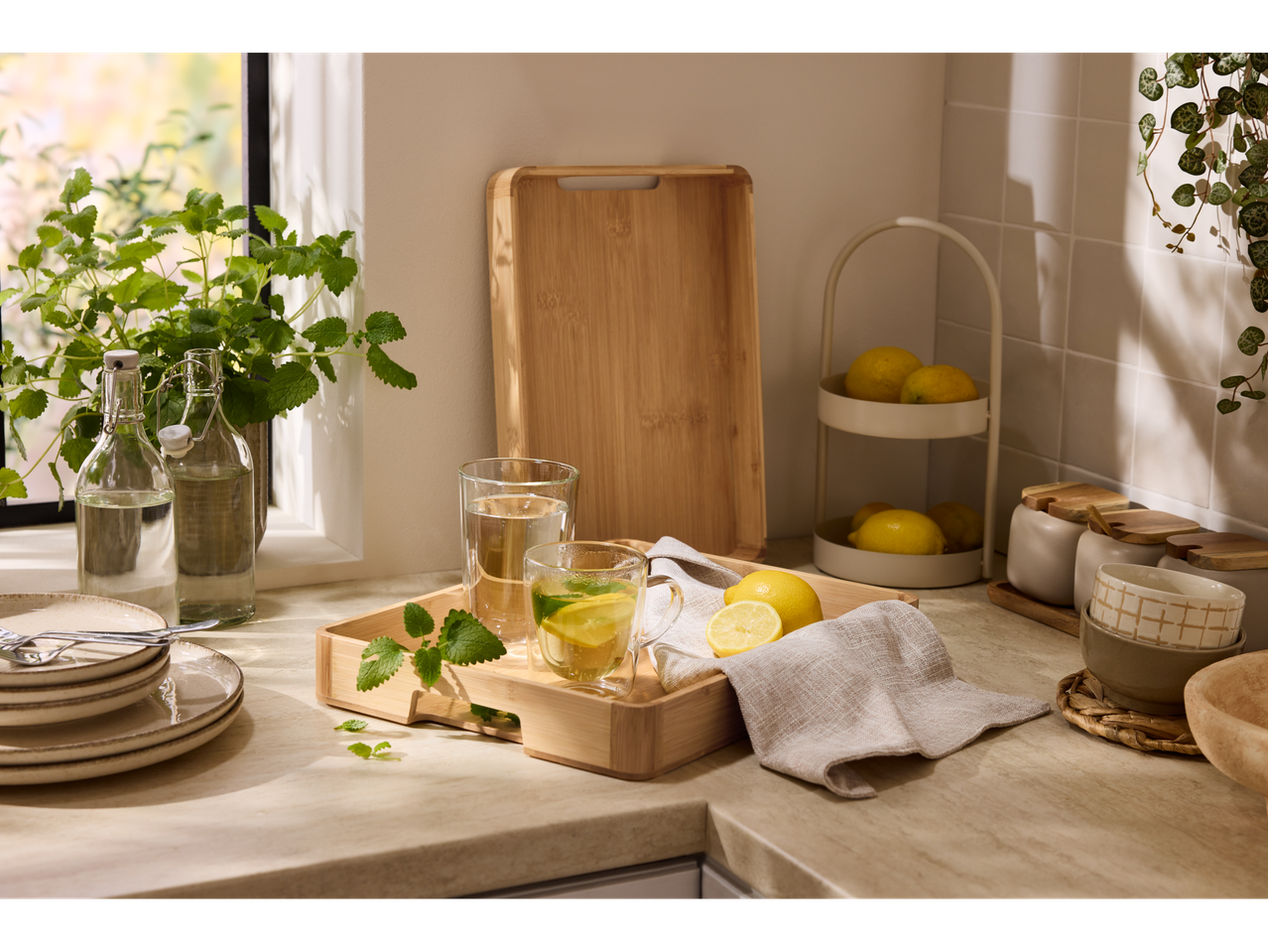 Silvercrest® padėklas su gėrimais, citrinomis ir mėtomis ant virtuvės stalviršio.