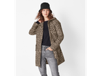 Woman in a leopard print jacket, black top, and gray jeans with a black bucket hat.