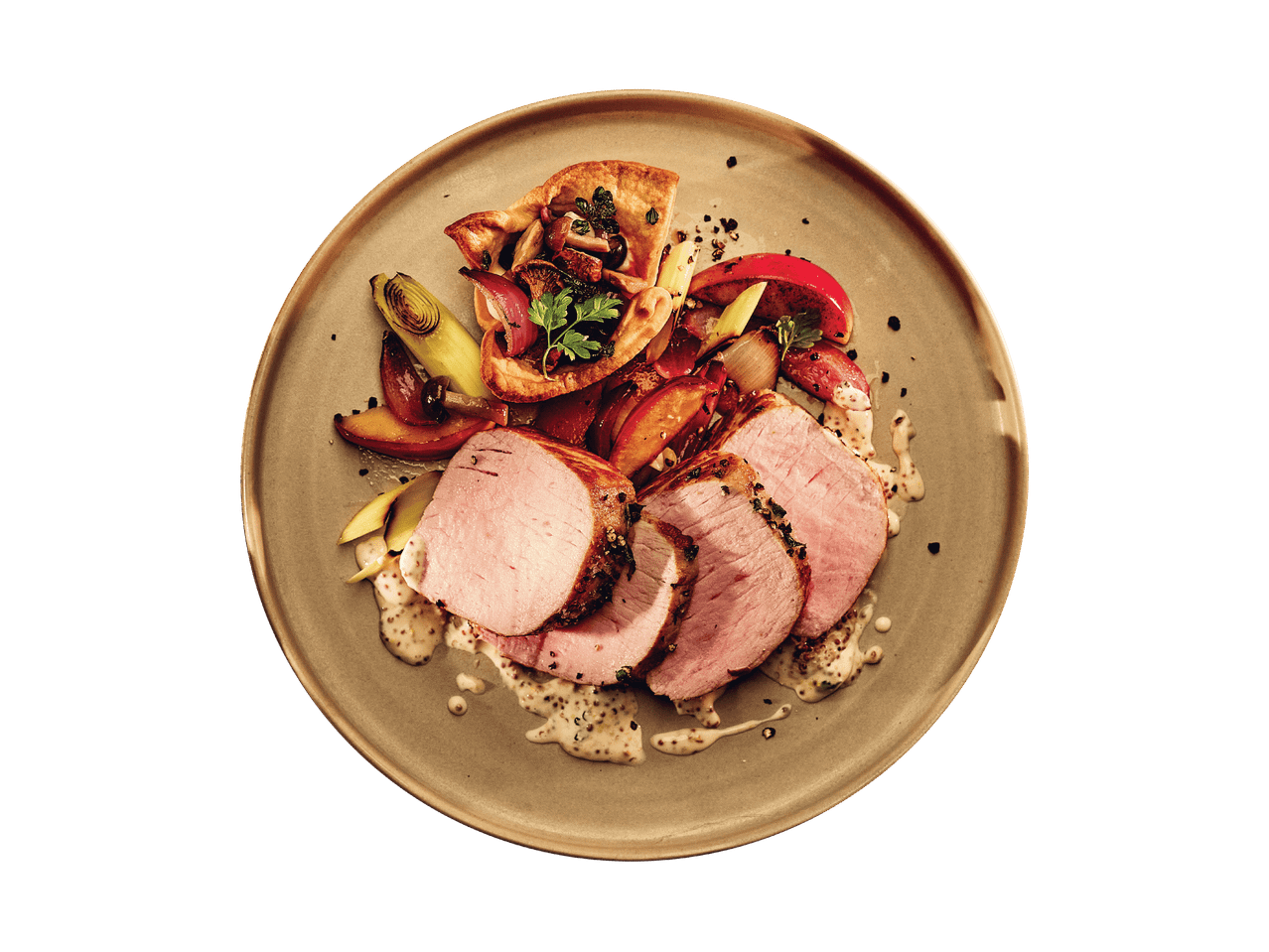 Gebratener Schweinefilet mit Gemüse, Pilzen und Senfsauce auf einem Teller.