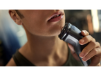 Close-up van een persoon die zijn kin scheert met een Philips elektrisch scheerapparaat.