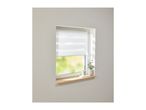 A window with white day and night blinds, a wooden sill, and decorative plants.