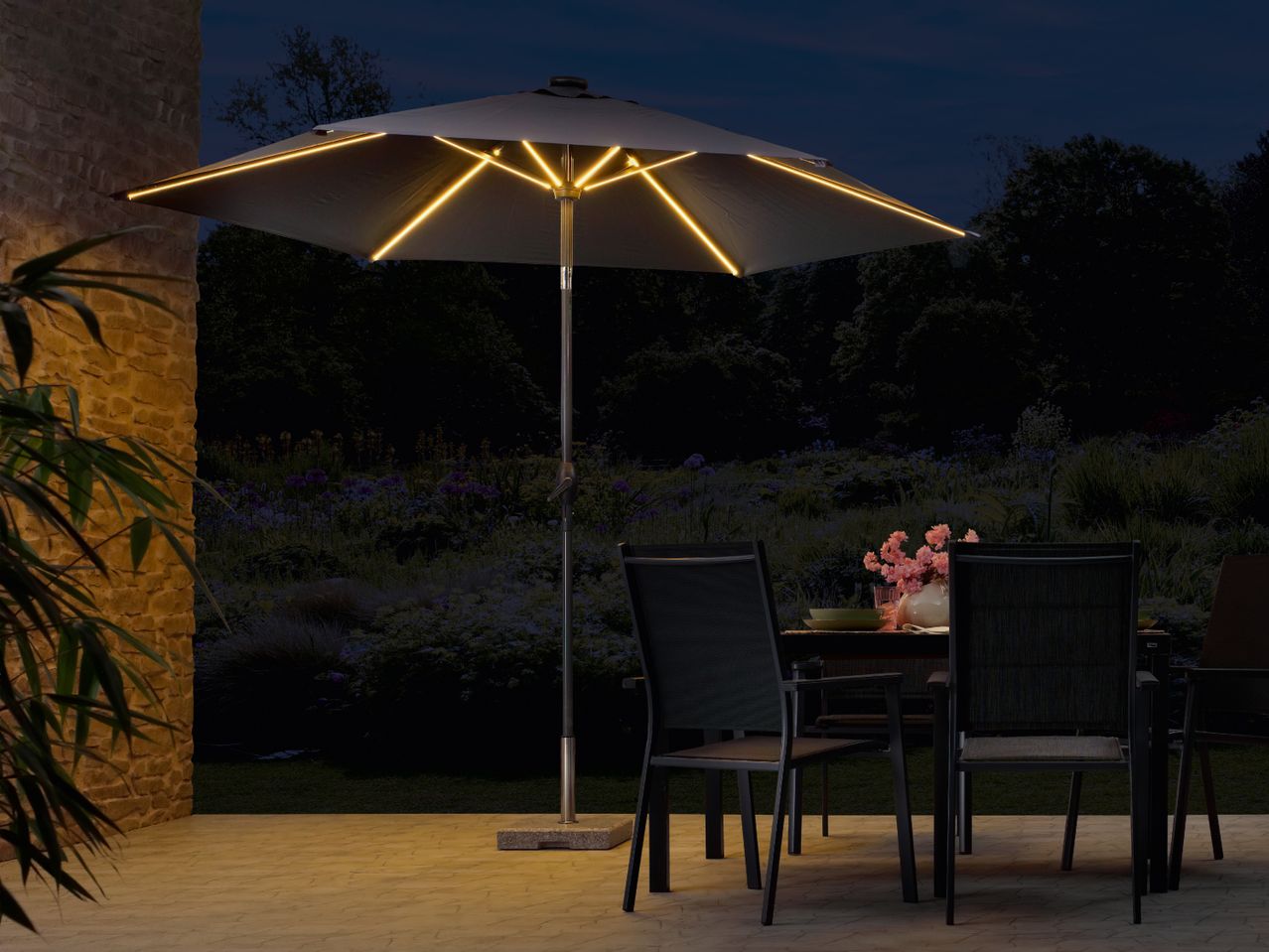 Parasol solaire éclairé avec table et chaises de patio.