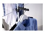 Clothes drying rack with white socks and blue shirts on hangers.