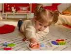 Un bambino gioca con un puzzle in legno LUPILU® su un tappeto