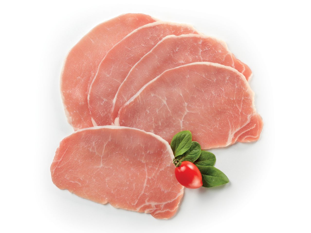 Fette di carne di maiale cruda, pronte per la cottura, guarnite con foglie di basilico e un pomodorino.