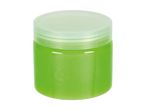 A small, cylindrical jar of light green cosmetic product with a translucent lid.