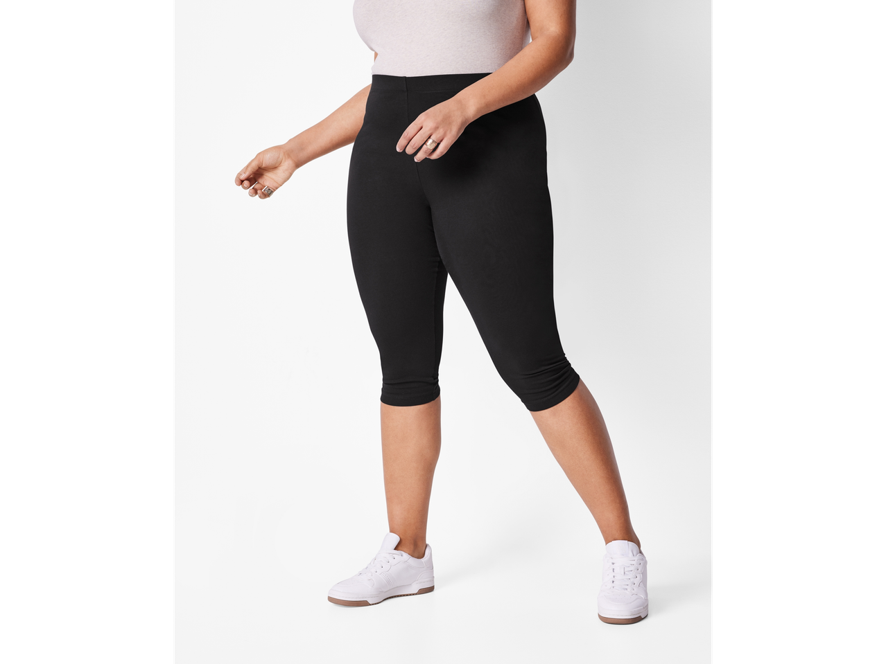 Ženska v črnih legicah in belih supergah.