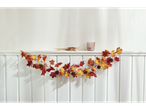 LIVARNO home autumn garland with leaves, pumpkins, and pinecones, with dried flowers and a candle holder on a shelf.