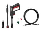 Black and red pressure washer with hose, nozzles, and cleaning accessories on a white background.