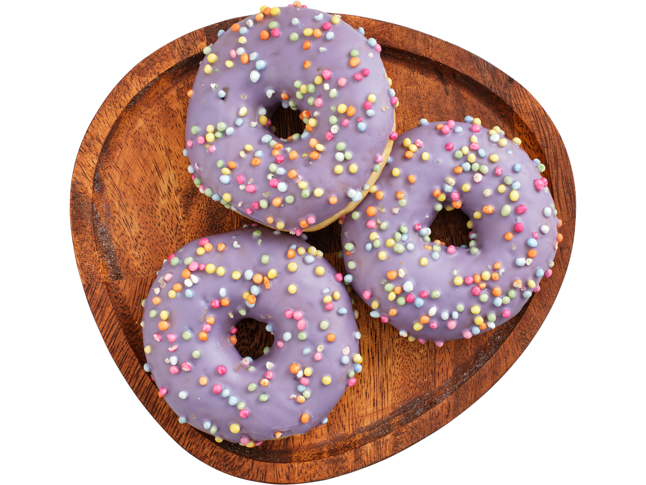 Trīs purpursarkanā glazūrā donuts ar krāsainām pabarstām uz koka šķīvja.