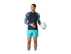 Man in a long-sleeved rash guard and swim shorts holding a volleyball.