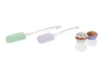 Two pastel-colored silicone spatulas and two cupcakes.