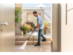 Man using a Kärcher 1600W Pressure Washer to clean outdoor patio steps.
