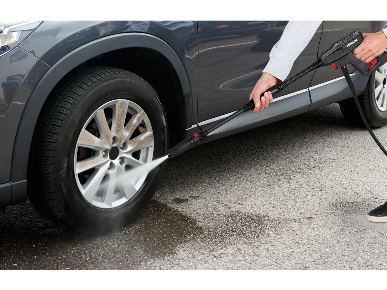 Aparat de spălat cu presiune PARKSIDE curățând o roată murdară de mașină.