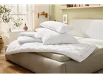 Soft white bedding set on a modern bed.