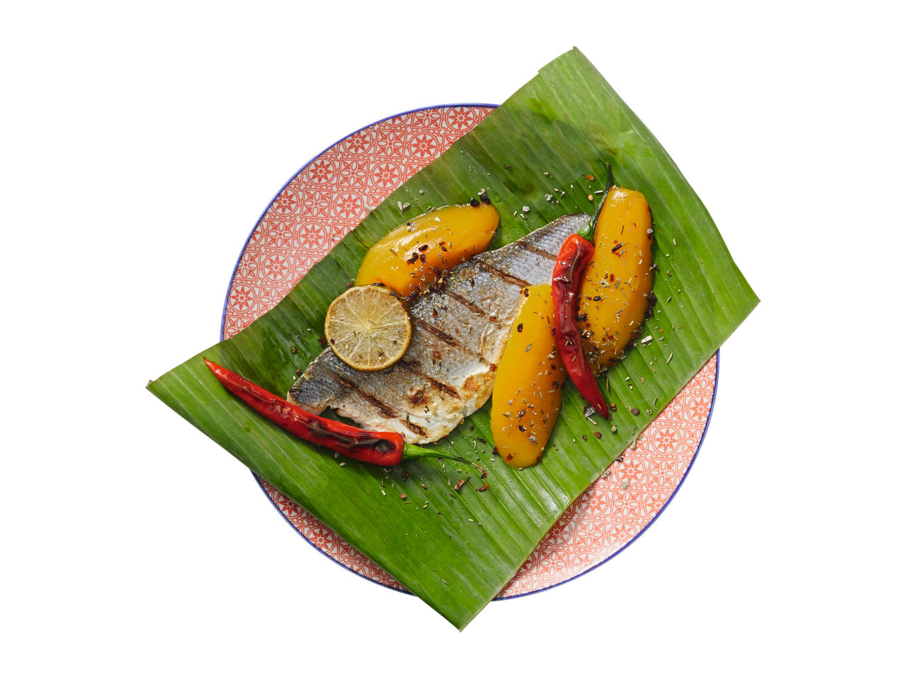 Gegrilde vis met mango en rode peper op bananenblad.