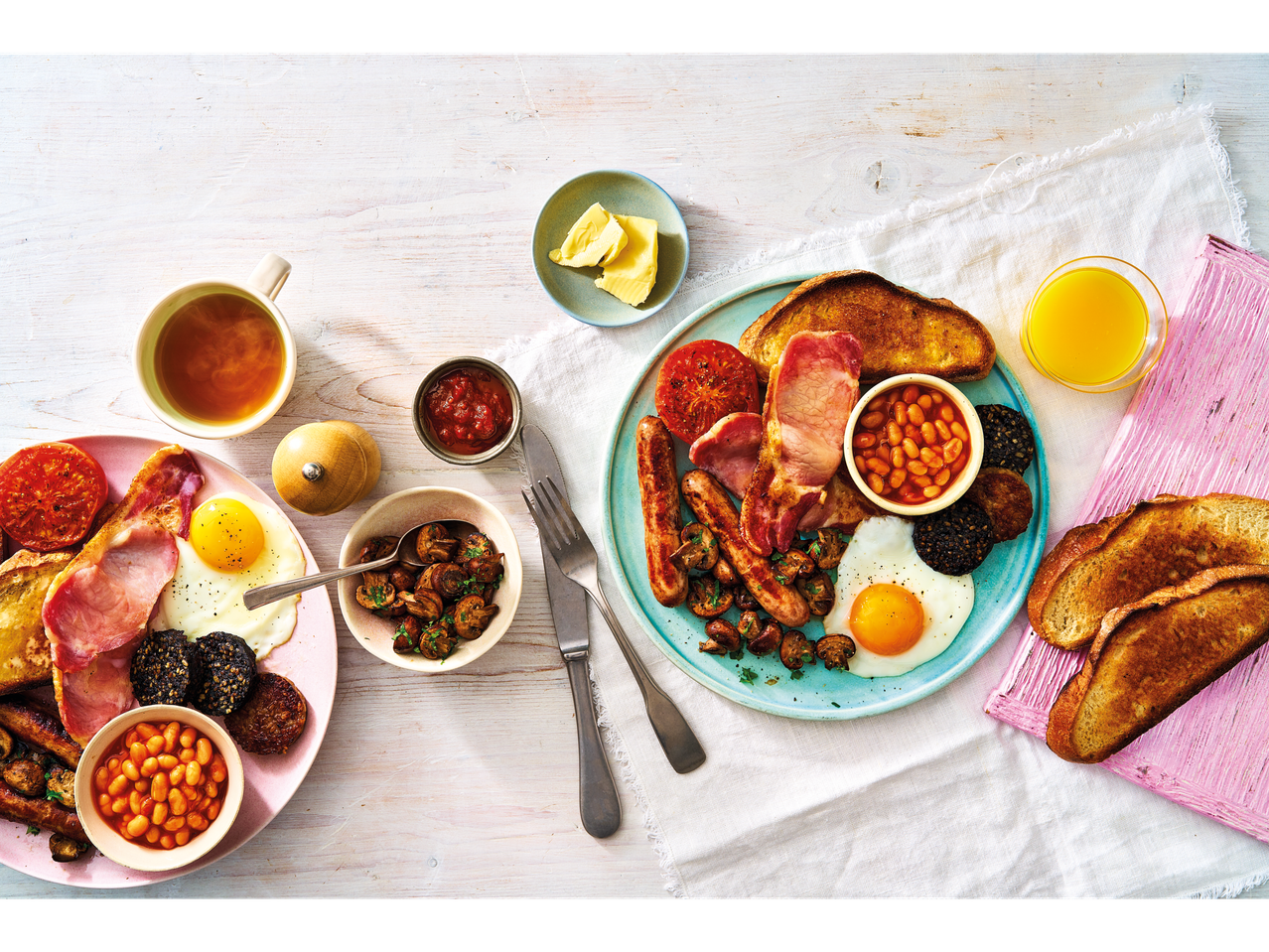 A delicious full Irish breakfast with fried eggs, bacon, sausages, baked beans, and toast.