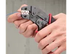Mâini sertizând un fir albastru cu un instrument de sertizare.