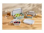 Collapsible food containers with salad, berries, and peppers on a wooden table.