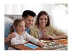 Family playing a board game with cards on a wooden table, smiling and engaged.