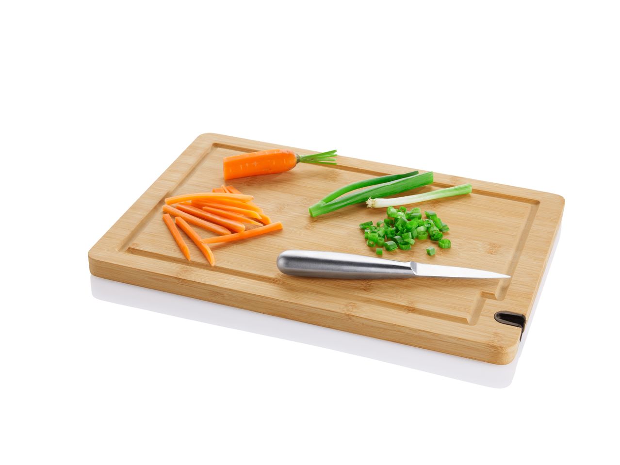 Bamboo cutting board with chopped carrots, spring onions, and a knife.