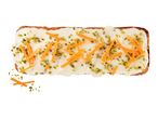 Carrot cake with cream cheese frosting, topped with carrot strips and pistachios.