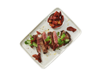 Italiamo sun-dried tomatoes and sliced steak on a plate.