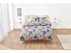 Set de lenjerie de pat cu flori pe un pat într-o cameră luminoasă.