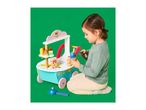 Child playing with a wooden ice cream and dessert stand on a green background.