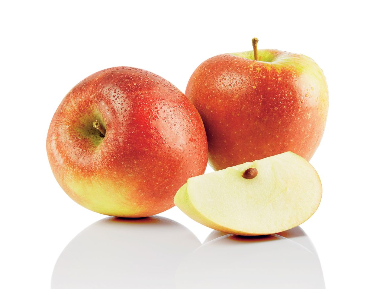 Deux pommes rouges et une tranche.