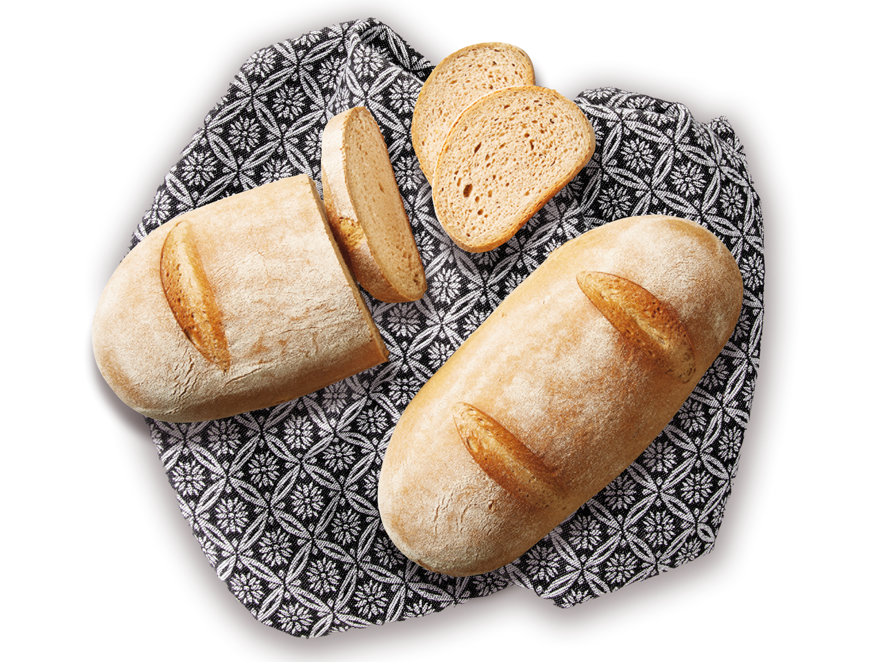 Dva kruha i narezan kruh na tkanini s uzorkom.