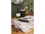 A black nose and ear hair trimmer with accessories on a towel in a bathroom setting.