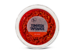 Tomatentapenade met olijven in een doorzichtige ronde verpakking, van bovenaf gezien.