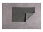 Gray bath mat with a textured surface on a tiled floor