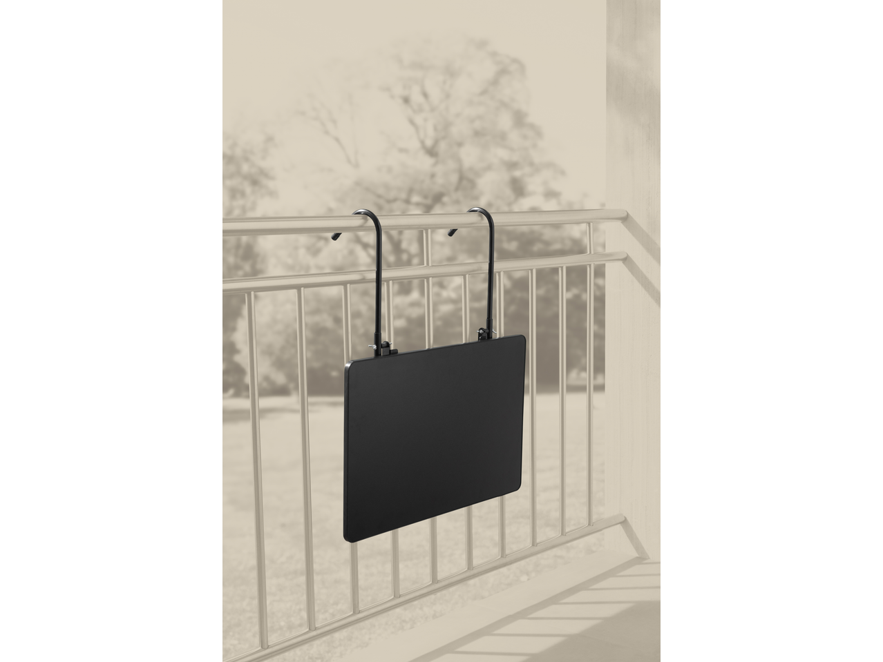 Mesa dobrável de varanda LIVARNO com tampo preto, pendurada num corrimão.