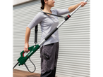 Woman using a Parkside® Extendable Pressure Washer Lance to clean a white roller shutter.