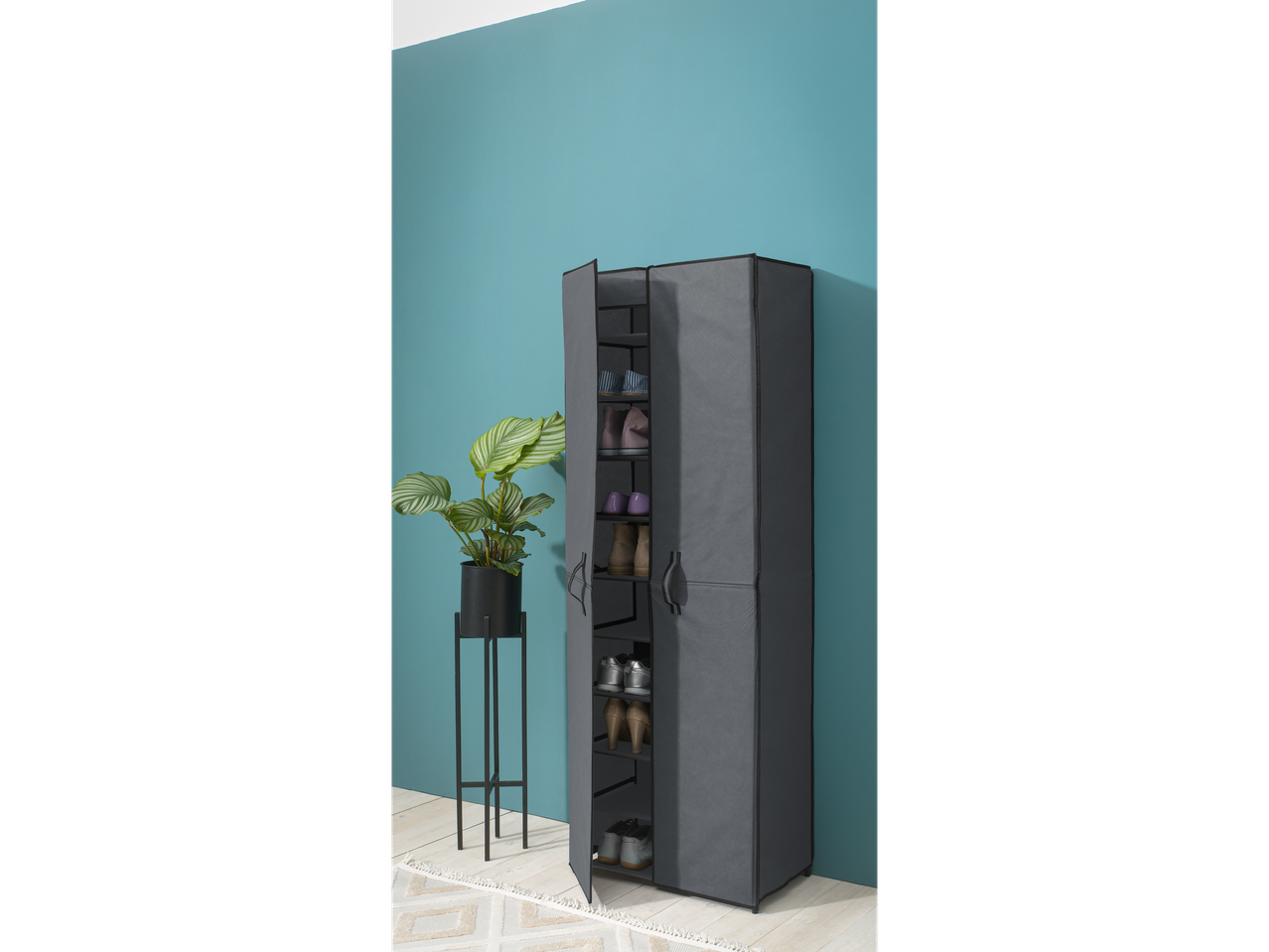 A gray fabric shoe cabinet with multiple shelves stands against a teal wall.