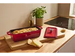 Pekač kruha din fontă SILVERCREST® cu pâine proaspăt coaptă pe un blat de bucătărie.