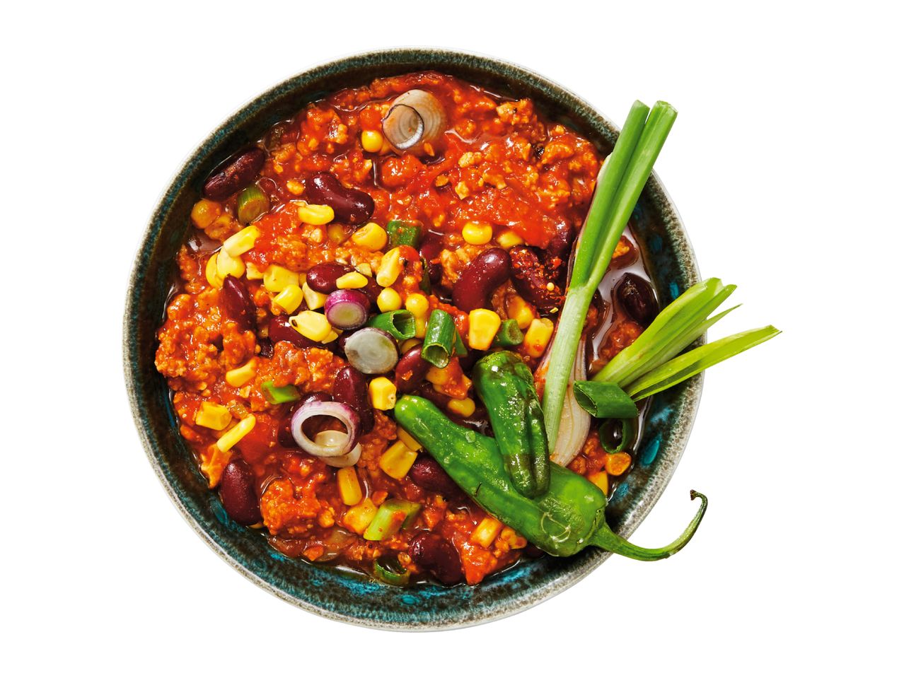 Overhead shot of chili con carne with kidney beans, corn, spring onions, and green chili peppers in a bowl.