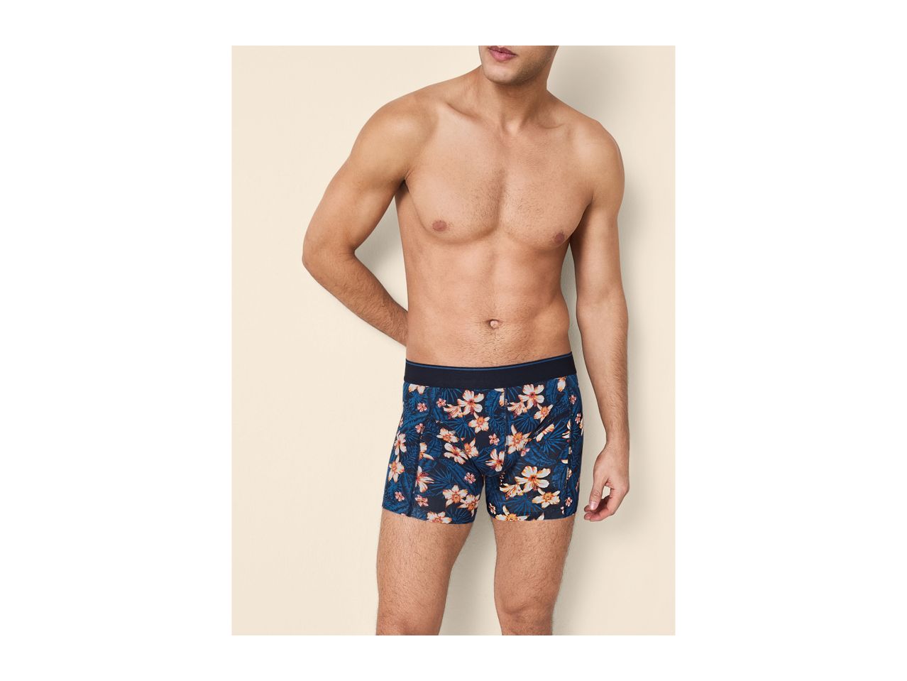 Man wearing blue boxer shorts with a tropical floral pattern.