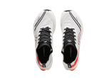 Crivit running shoes in white with black and orange details, top view.