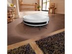 A white SILVERCREST® Robot Vacuum Cleaner cleans a brown floor in a modern home.