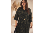 Un model plus size poartă o rochie midi verde închis cu imprimeu leopard și o curea cu cataramă aurie.