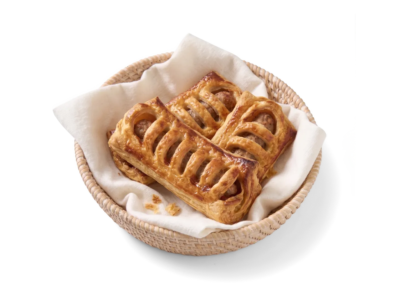 Drie hartige bladerdeeggebakjes met worstvulling in een rieten mand met een witte doek.