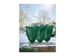 Three small garden plants covered with green winter protection fleece bags in a snowy garden.
